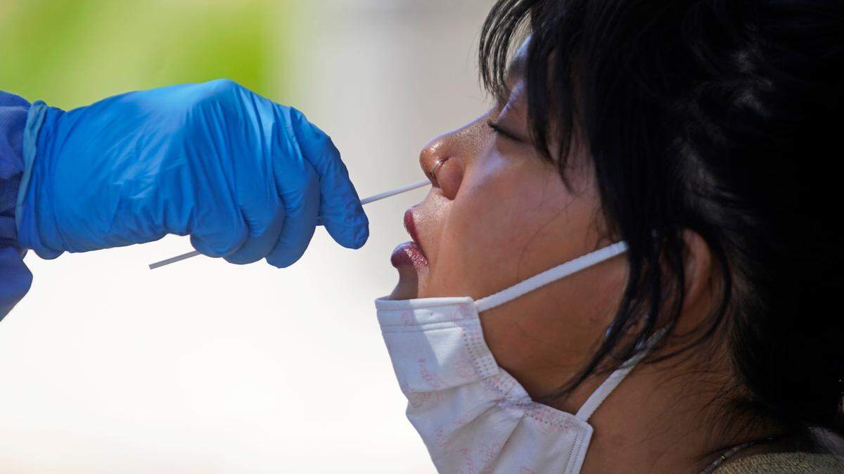 In this file photo, a woman receives a COVID-19 test outside the Salt Lake County Health Department Tuesday, June 21, 2022, in Salt Lake City.