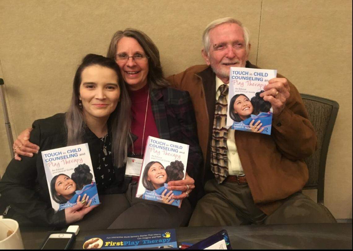 Robert Nolan (right) and his wife Janet A. Courtney-Nolan (center) and Meyleen Velasquez (left) celebrate the Nolans’ work with Play Therapy.