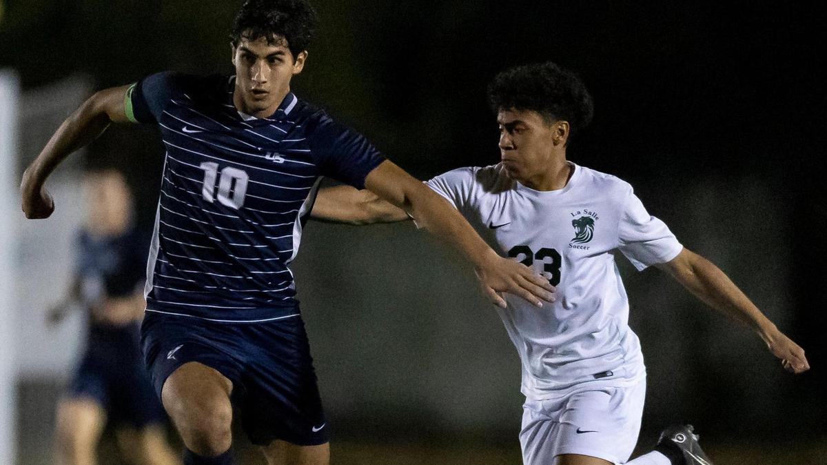 NSU University School’s Rafael Guerra (10) dribbles with the ball as La Salle’s Kevin Ceballos (23) defends during the second half of a Region 4-3A boys’ soccer final at NSU University School on Wednesday, Feb. 15, 2023.