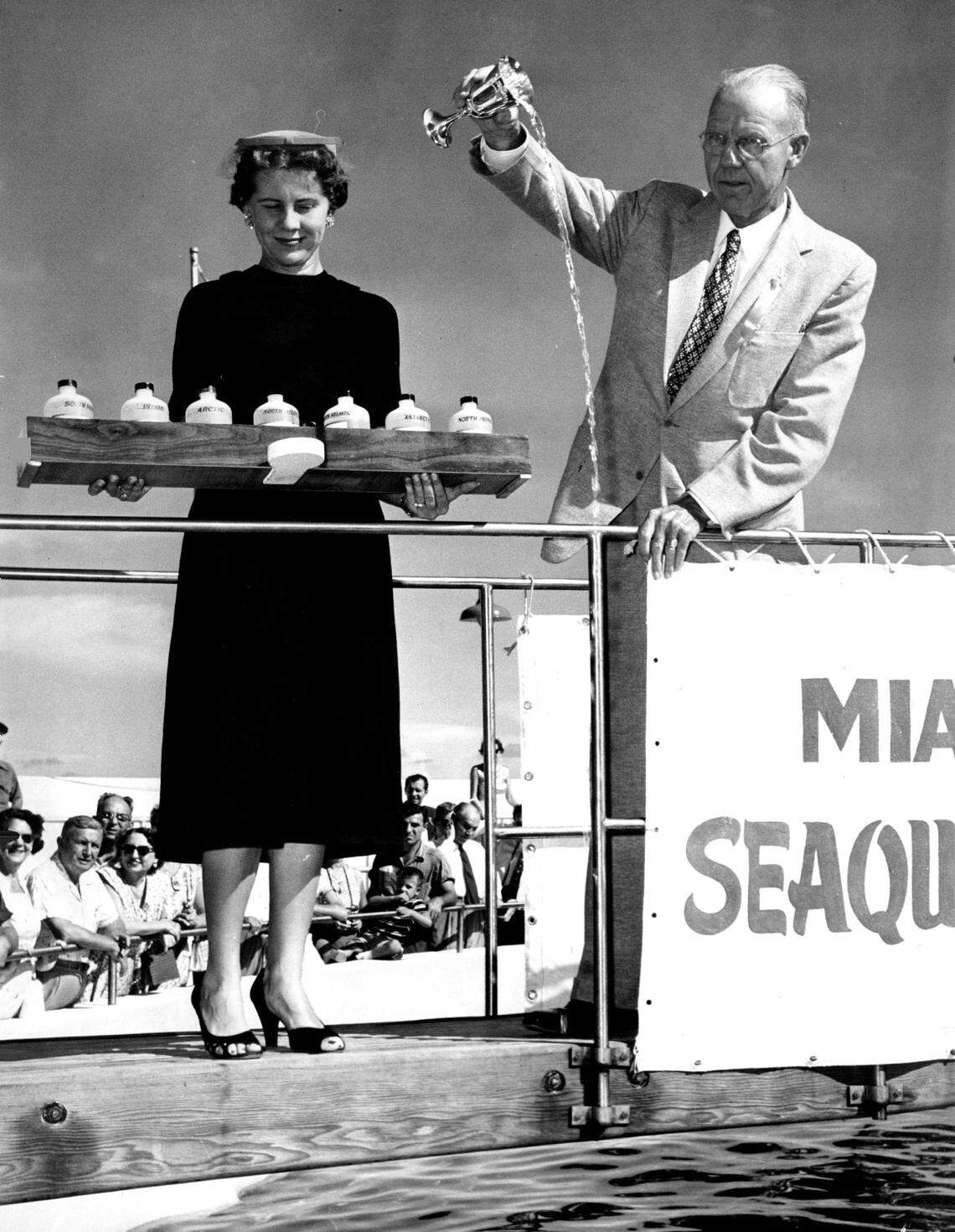 Lord Gavin Astor of London, England, hand-feeds Clown, the Miami Seaquarium's high-jumping porpoise.