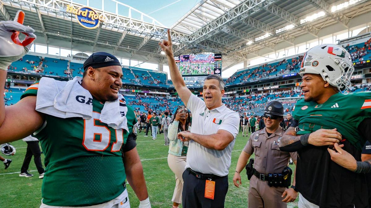 Miami Hurricanes head coach Mario Cristobal celebrates the win against the Wake Forest Demon Deacons with offensive lineman Francis Mauigoa (61) and tight end Elijah Arroyo (8) in the second half of their NCAA game in Miami Gardens, Florida, on Saturday, November 23, 2024.