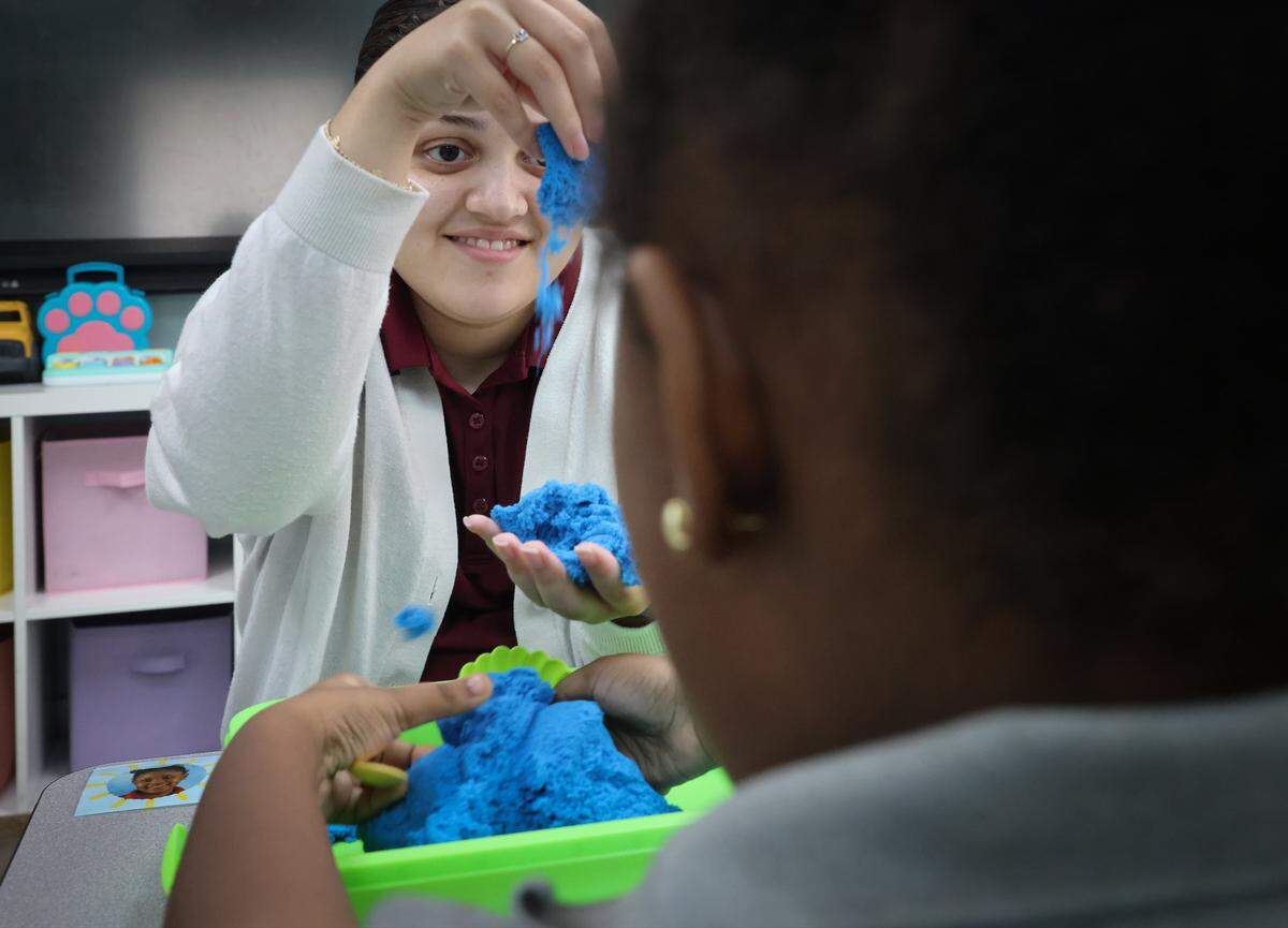 RBT Guadalupe Almanza engages with student Royana Pierre in the Yellow Class. The Miami Herald was given tour of the school as it tries to continue to serve the needs of children with autistic students on Monday, September 23, 2025.