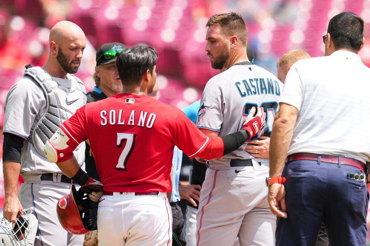 Cincinnati Reds’ Donovan Solano (7) speaks with Miami Marlin’s starting pitcher Daniel Castano (20) after hitting him with a line drive during the first inning of a baseball game Thursday, July 28, 2022, in Cincinnati. (AP Photo/Jeff Dean)