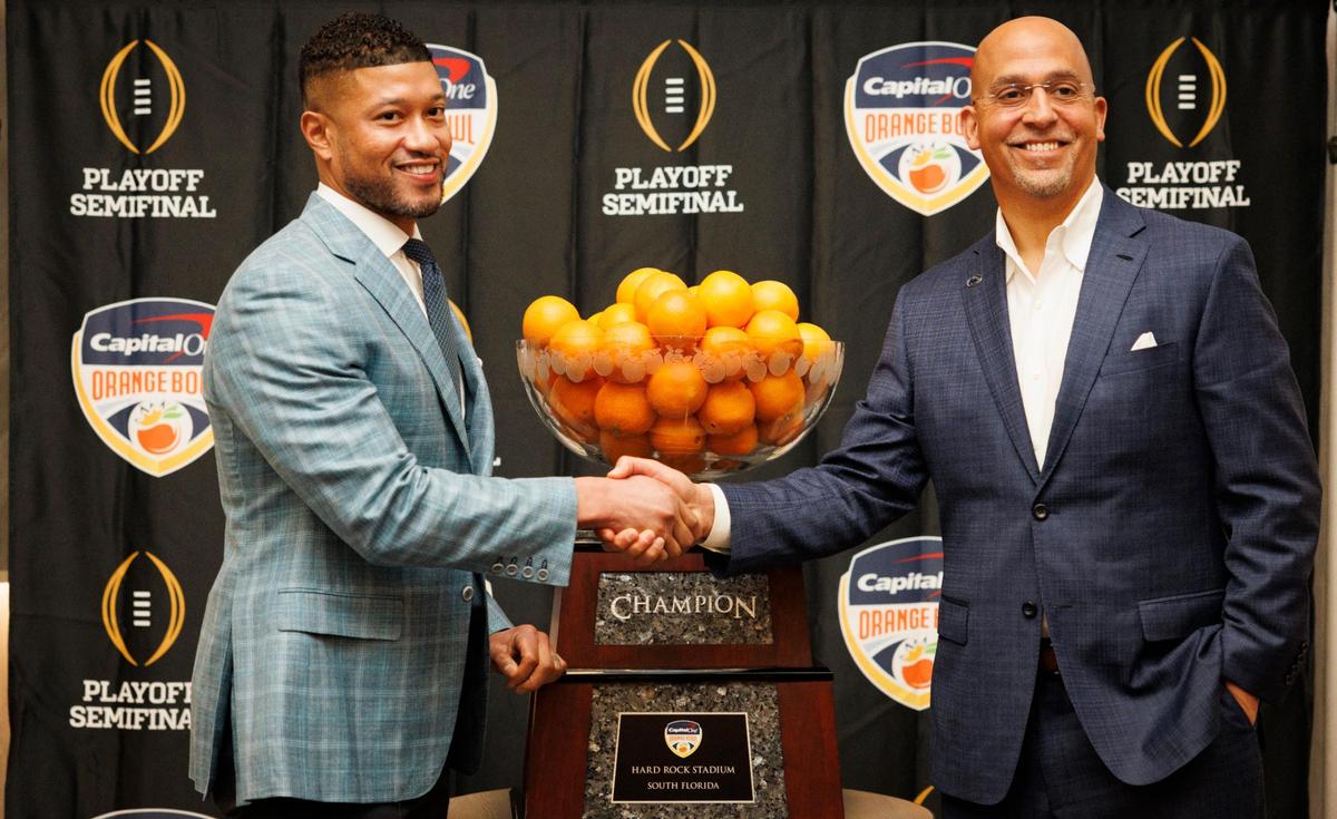 Notre Dame Head Coach Marcus Freeman, left, and Penn State Head Football Coach James Franklin shake hands in front of the Orange Bowl trophy after a press conference on Wednesday, Jan. 8, 2025, at Le Meridien hotel in Dania Beach.