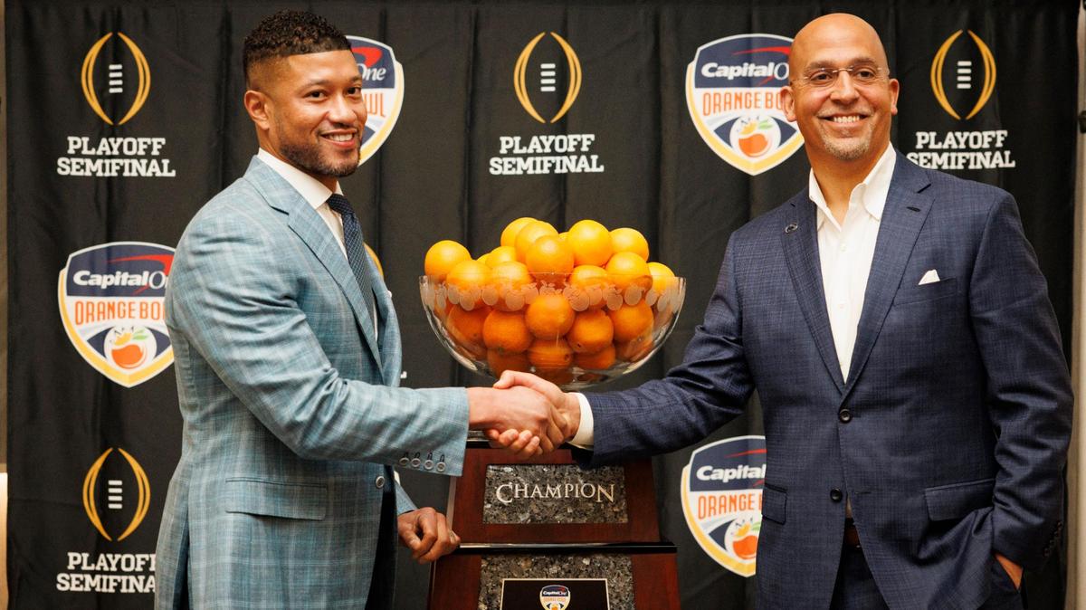 Notre Dame Head Coach Marcus Freeman, left, and Penn State Head Football Coach James Franklin shake hands in front of the Orange Bowl trophy after a press conference on Wednesday, Jan. 8, 2025, at Le Meridien hotel in Dania Beach.