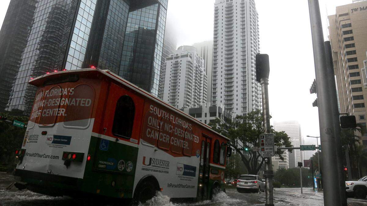 A Miami-Dade County trolley drives through a flooded Brickell Avenue in Miami on Monday, May 25, 2020.