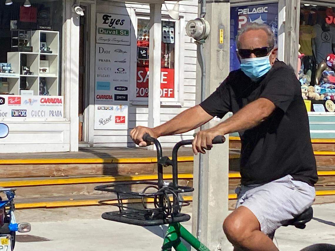 A bicycle rider masks up during a ride up Duval Street in Key West on July 16, 2020.