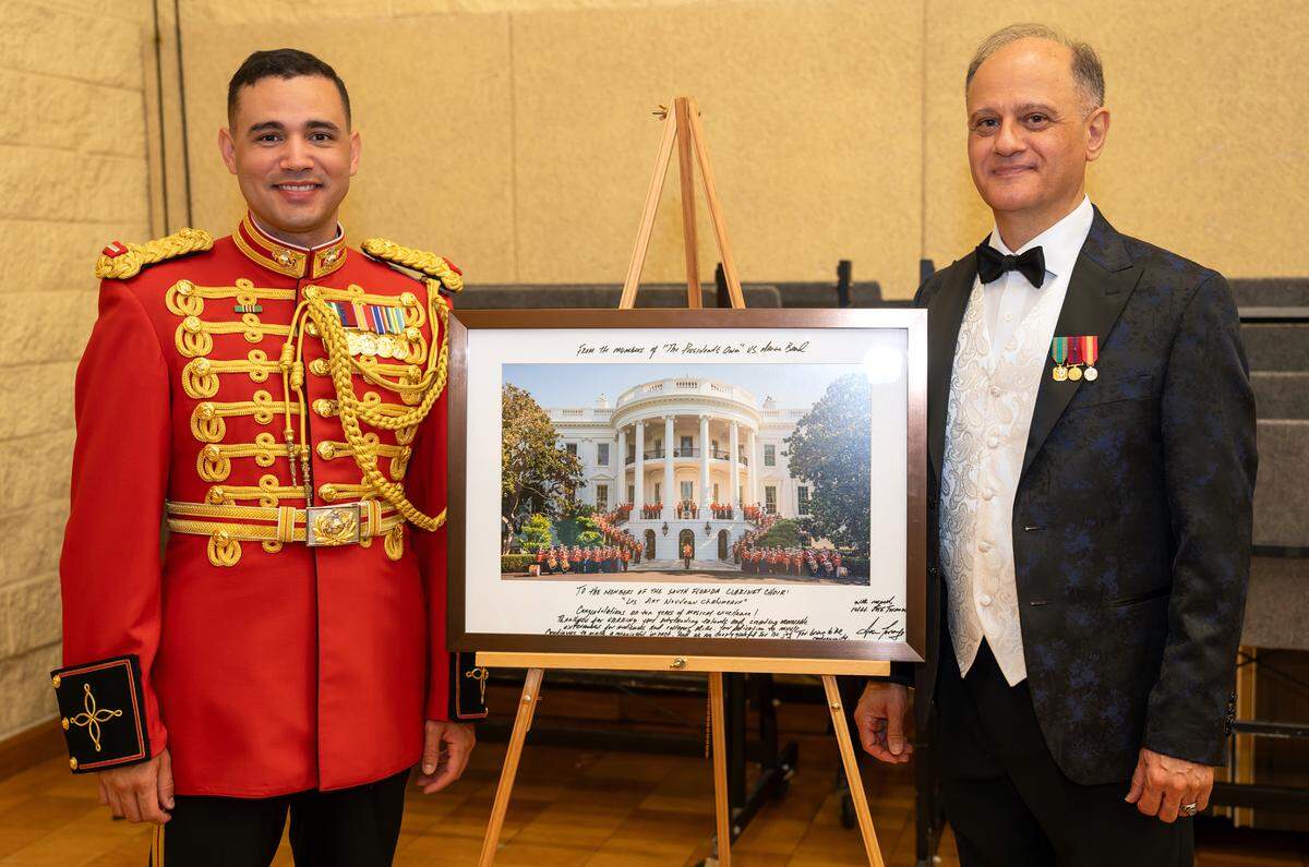 First Lieutenant Jose D. Toranzo, a Coral Gables High School graduate and assistant director of ‘The President’s Own’ United States Marine Band, presents a picture of the band to Richard A. Zogaib, director of the South Florida Clarinet Choir, before the organization’s 10th Anniversary Concert.