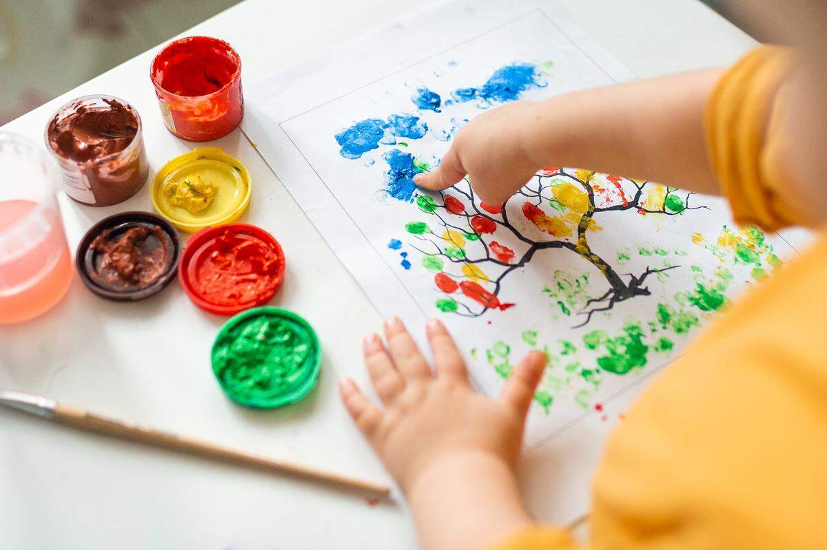 baby finger painting with different colors