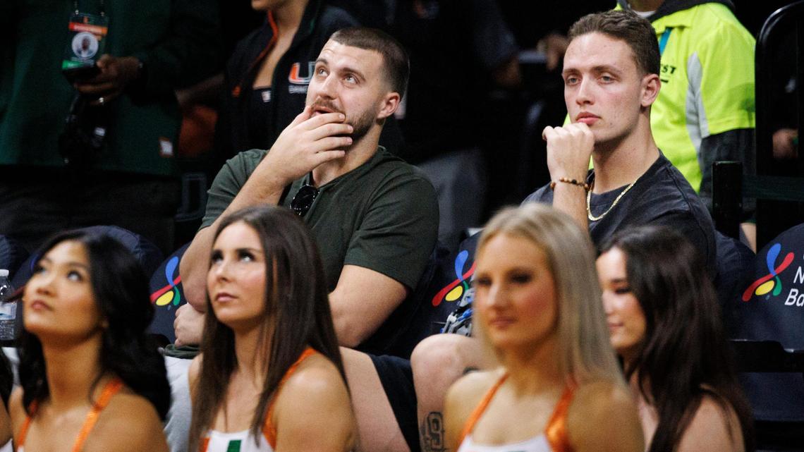 Jake Ferguson, NFL tight end, left, and Carson Beck, college football quarterback, watch their girlfriends, the Cavinder twins, play during the second quarter of a game on Thursday, Jan. 30, 2025, at Watsco Center in Coral Gables, FlA.