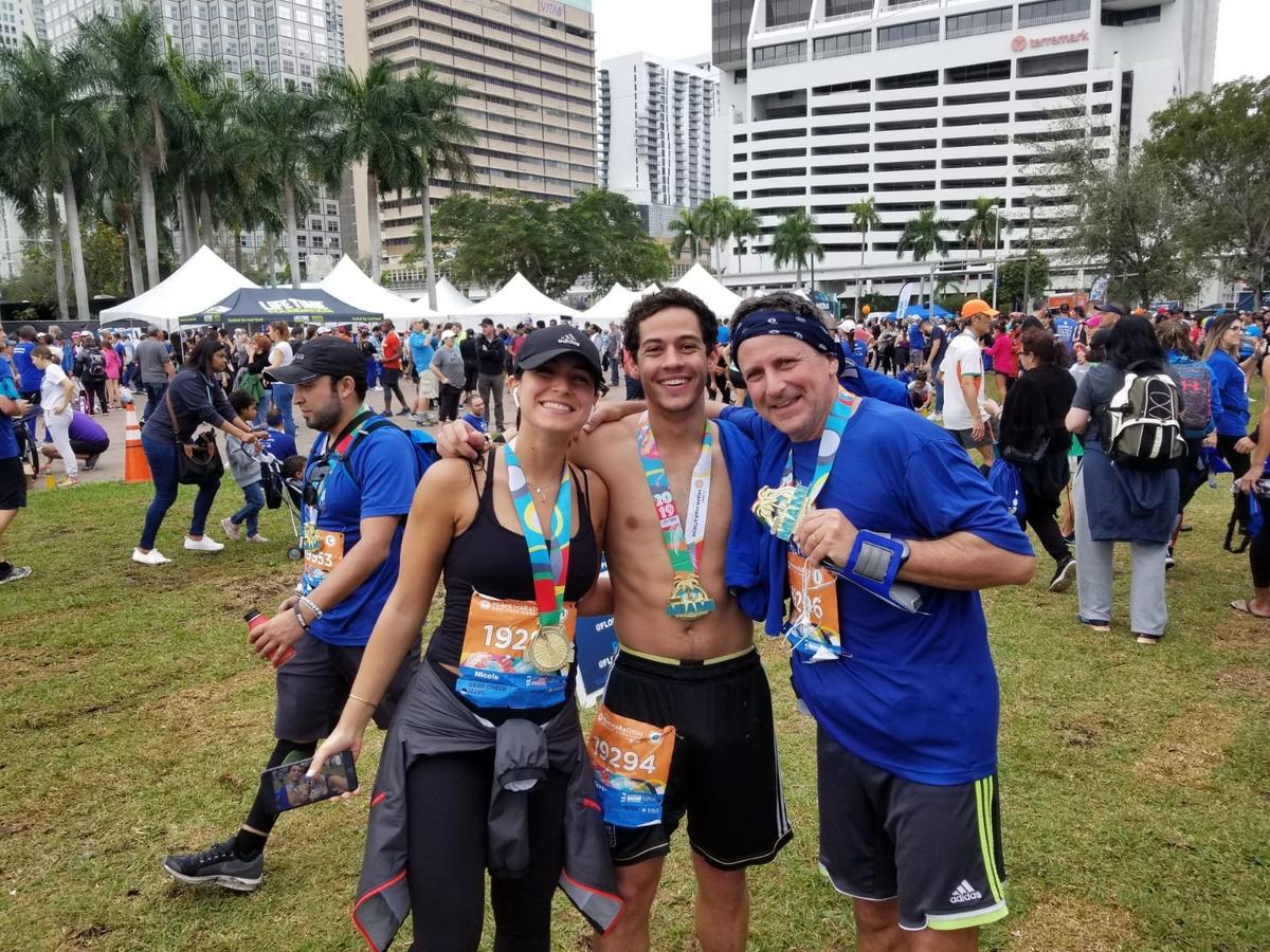 From left, Nicole Langesfeld, Martin Langesfeld, and their father, Pablo Langesfeld, pose at Bayfront Park after completing the 2019 Miami Half Marathon.