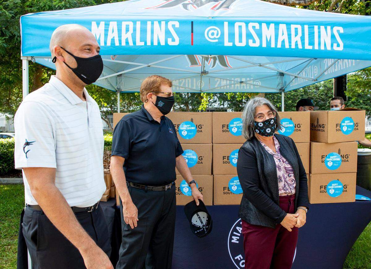 Miami Marlins Chief Executive Officer Derek Jeter, left, Chairman & Principal Owner Bruce Sherman, center, and Mayor of Miami-Dade County, Daniella Levine Cava, right, during the 12th annual Home Plate Meals Thanksgiving Distribution sponsored by Tito’s Handmade Vodka, in Little Havana, Florida, on Monday, November 23, 2020. Each meal box will contain approximately 40 pounds of food, serving more than 20,000 meals.