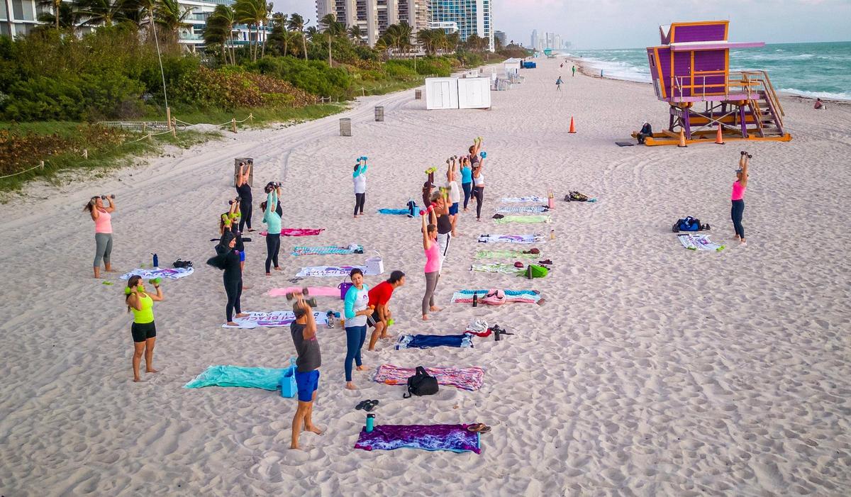 Certified personal trainer Kristen Smith (far right) leads a fitness class in the sand on Tuesday, Jan. 23, 2024 as part of her early morning Miami Beach Fit Camp program. She used to weigh 405 pounds and has lost more than 240 pounds since 2006. She will run her first Life Time Miami Marathon on Sunday, Jan. 28th.