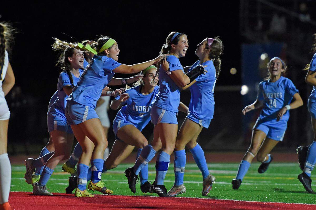 Lourdes’ Coco Aguilar is at the center of a celebration with her teammates after scoring one of her two goals in the Bobcats’ 2-0 win over St. Thomas Aquinas in the Region 4-6A final on Tuesday night at Monsignor Pace.