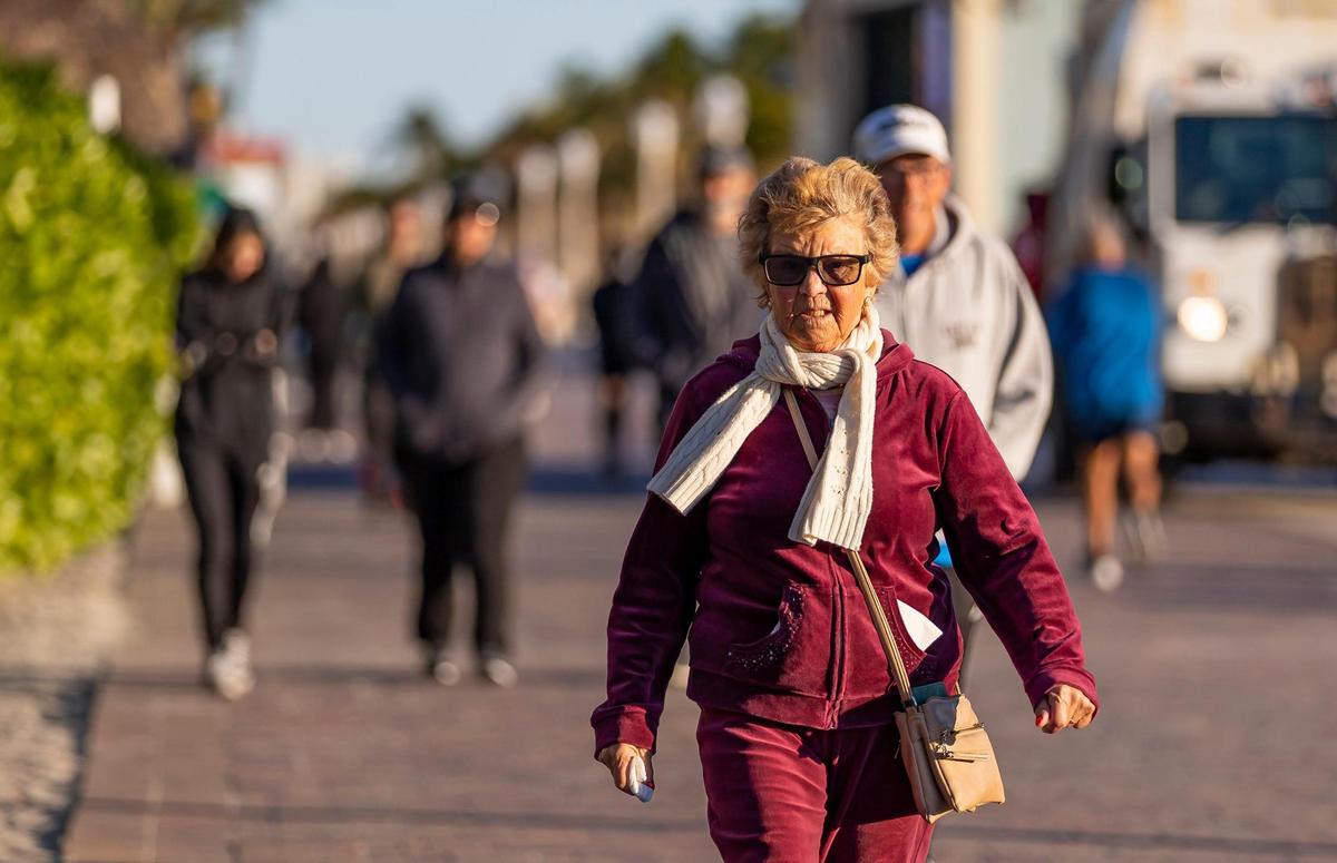 Una visitante recorre Hollywood Beach Broadwalk mientras las temperaturas bajan a mediados de los 40 el sábado, 14 de enero de 2023, en Hollywood, Florida.