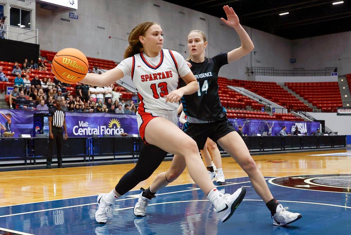Miami Country Day’s Jalynn Belton (13) looks to pass the ball under the basket as Providence School’s Kasey Davey (14) defends in the second half of the FHSAA Class 2A Girls High School Basketball State Championship at the RP Funding Center in Lakeland, Florida on Saturday, March 1, 2025.