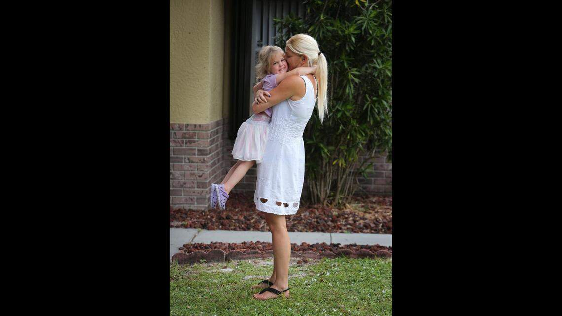 Brooklyn gets a big hug as mom Ashley Grant lifts her out of her wheelchair to carry her inside their home in Cocoa, Florida.
