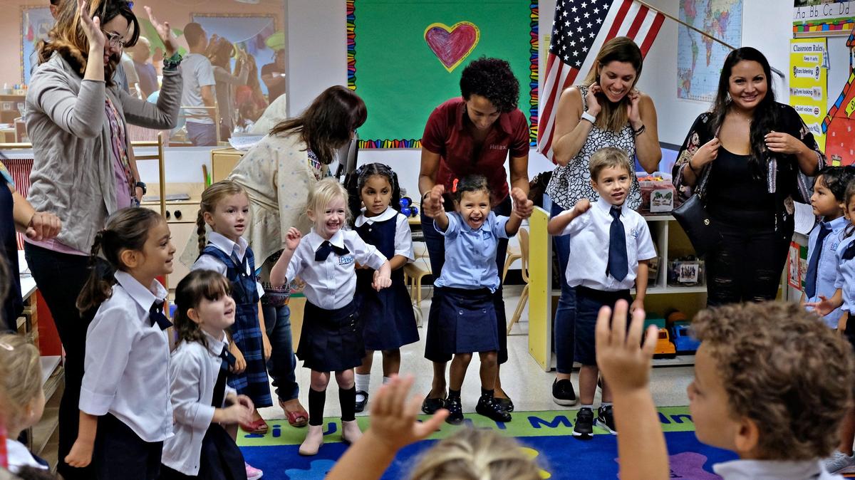 La maestra Kelly Barge dirige a los padres y sus alumnos de preescolar en una canción para reducir el estrés y la ansiedad durante el primer día de clases el 19 de agosto de 2019, en la iPrep Academy.