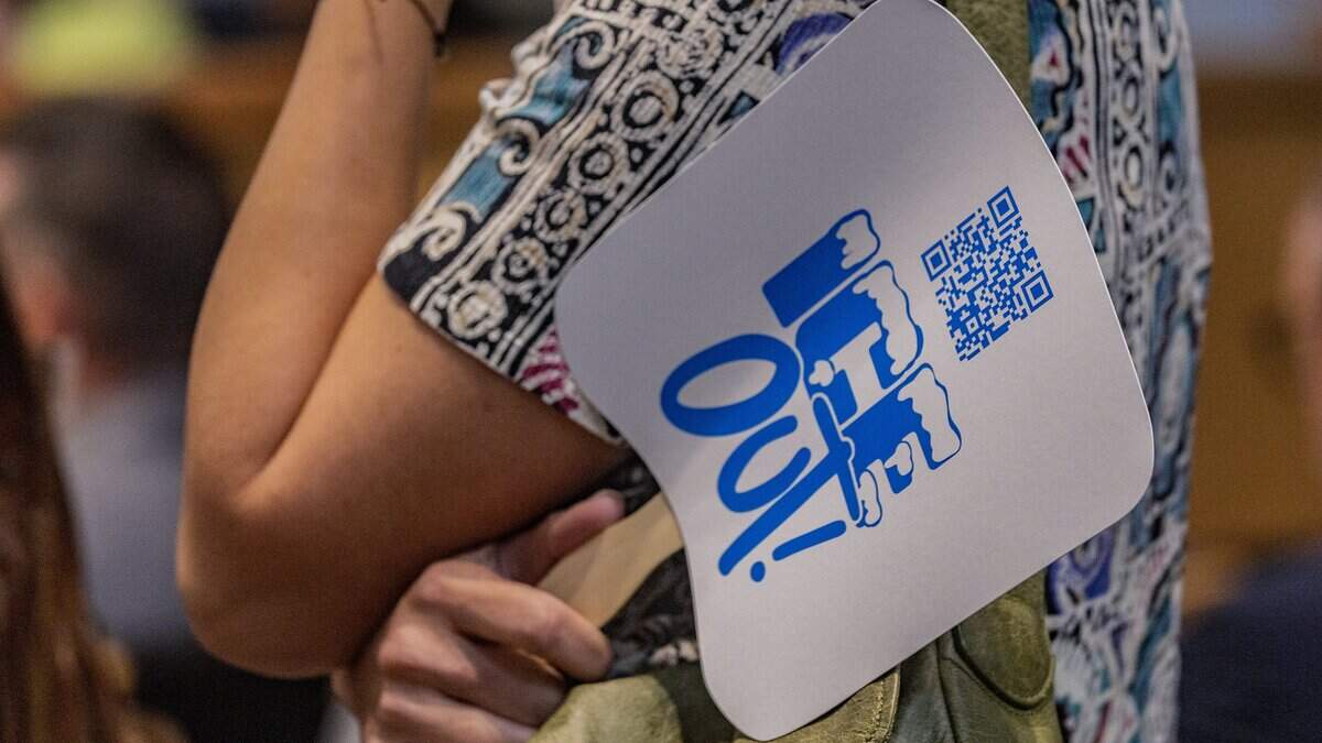 A resident displays an anti ICE sign before speaking against the 287(g) agreement with ICE that the City of Miami commission voted in favor to enter into last year, during a Miami City Commission meeting, at City Hall, on Thursday June 25, 2026.
