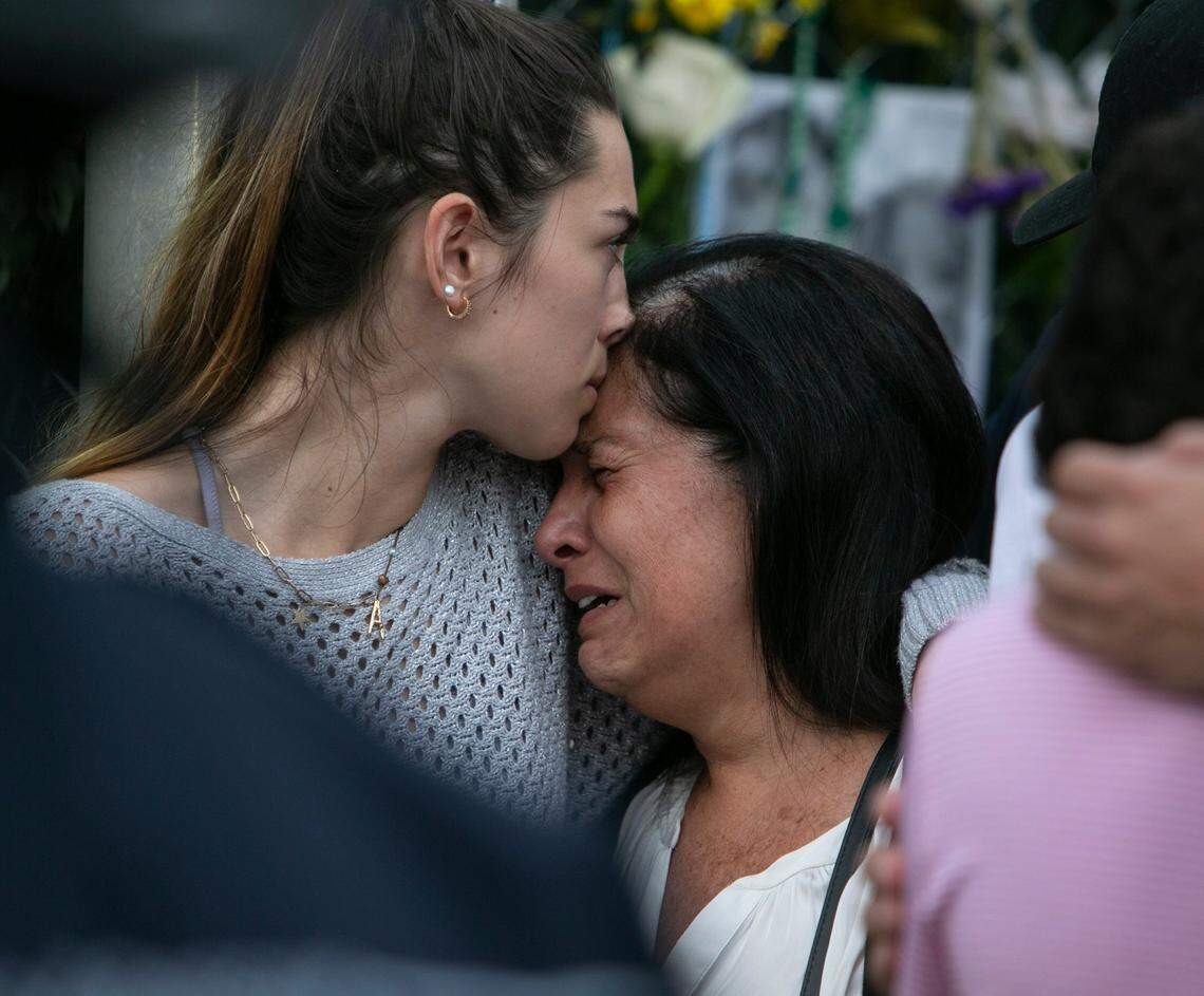 Alejandra Torres kisses Andrea Langesfeld, mother of Nicole Langesfeld, who died in the Surfside collapse, during a vigil at the memorial wall near the site of the collapse.