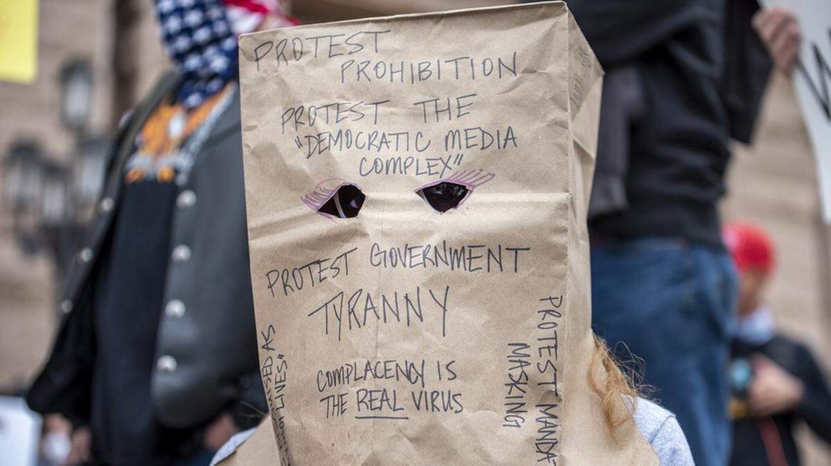 Anti-lockdown protester wears discontent on a paper bag.