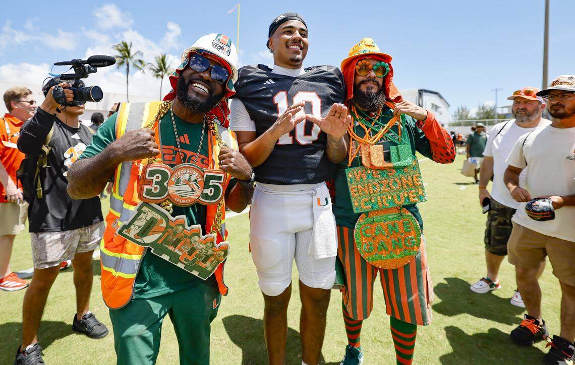 Miami Hurricanes fans JD Da Boss, at left, and Bobby Johnson, right, pose for photos with quarterback Darian Mensah (10) after UM’s spring football game at Cobb Stadium on the University of Miami campus in Coral Gables, Florida, on Saturday, April 18, 2026. 