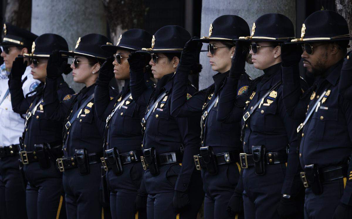 City of Miami officers, along with honor guards from all over South Florida, line the streets for the procession into a funeral service for Miami Beach Police Sergeant David Cajuso on Wednesday, Nov. 12, 2025, at the Hard Rock Stadium in Miami Gardens, Fla.