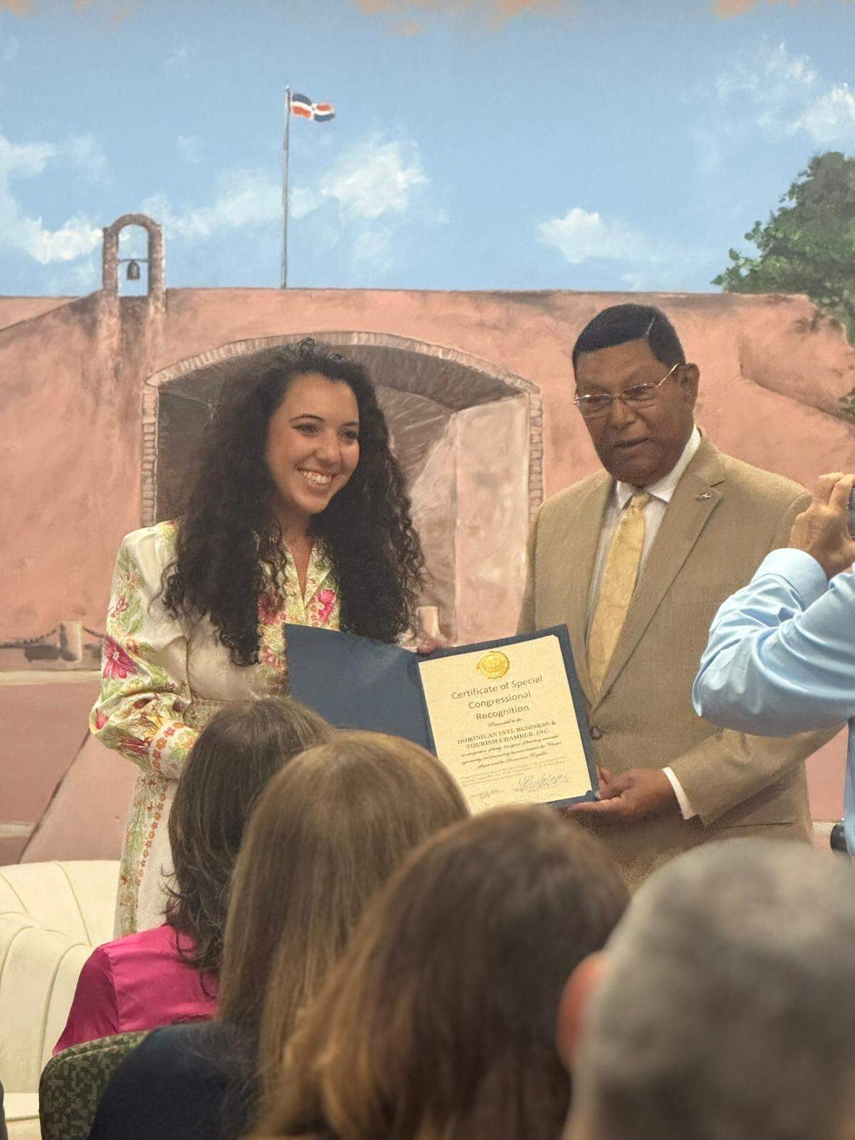 Eyvana Bengochea, senior advisor in the office of Congresswoman María Elvira Salazar, presents Pedro J. Díaz Ballester, president of the Dominican International Chamber of Business and Tourism, with a special congressional recognition certificate for his 45 years of promoting trade, business, tourism, investment, and development relations between the United States and the Dominican Republic.