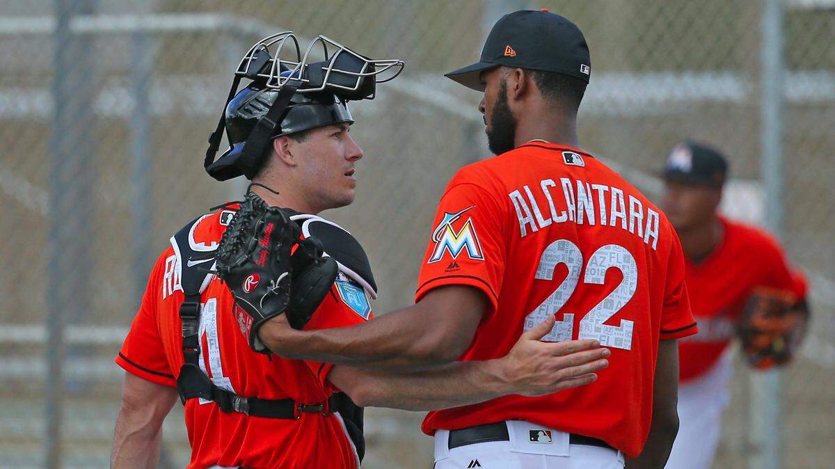 Miami Marlins pitcher Sandy Alcantara (22) talks with catcher J.T. Realmuto pitches during the spring training baseball workouts for pitchers and catchers at Roger Dean Stadium on Wednesday, February 14, 2018, in Jupiter, Fla.
