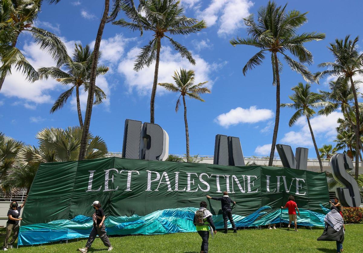 A group protesting for ceasefire in support of Gaza stopped to unveil a banner as they marched towards Bayside in downtown Miami Monday, April 15, 2024.