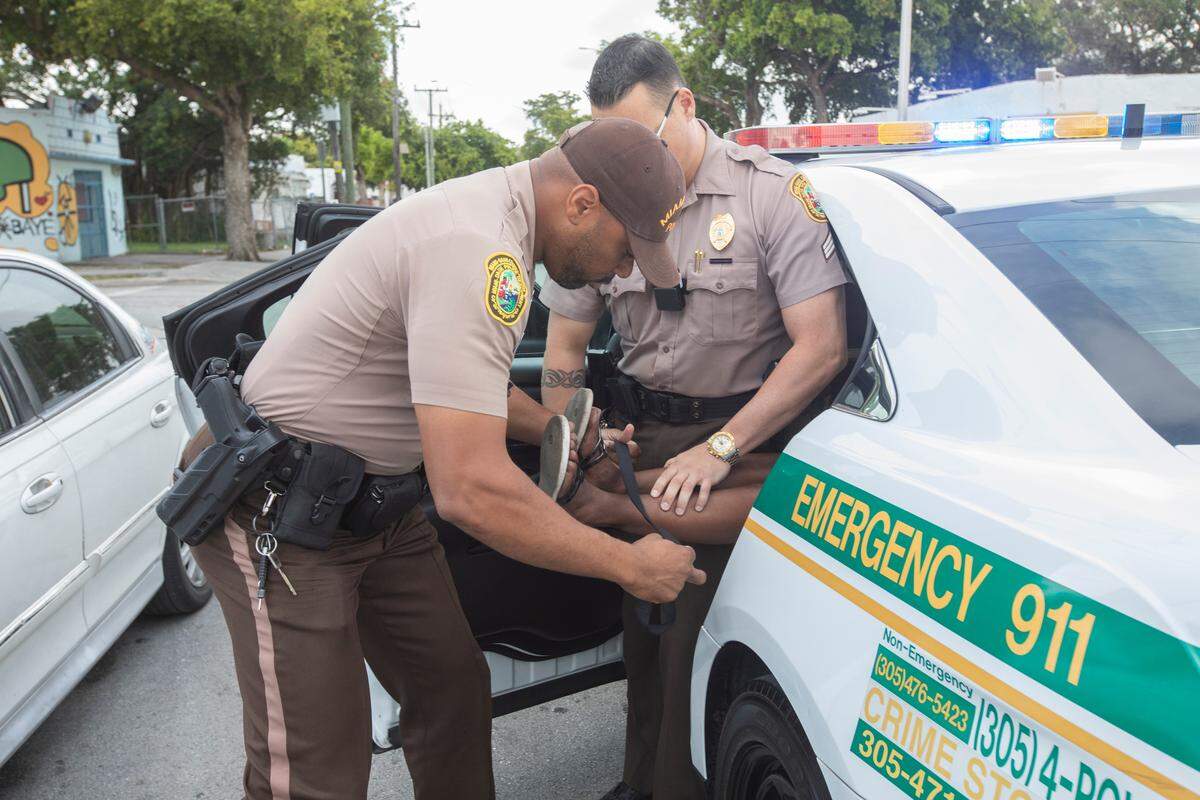 Miami-Dade officer Zuri Chambers, foreground, and Sergeant Jason Waite apprehend a woman who had stripped off her clothes during an encounter on a street in the Northside police district on Friday, Dec. 28, 2018.