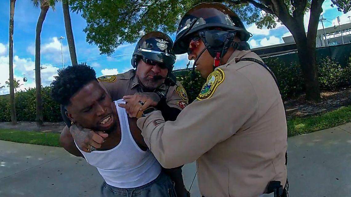 Miami-Dade police officer Danny Torres, left, wraps his arm around the neck of Miami Dolphins star receiver Tyreek Hill in this Miami-Dade police body camera footage of Hill’s controversial traffic stop Sunday, Sept. 8, 2024, near Hard Rock Stadium.