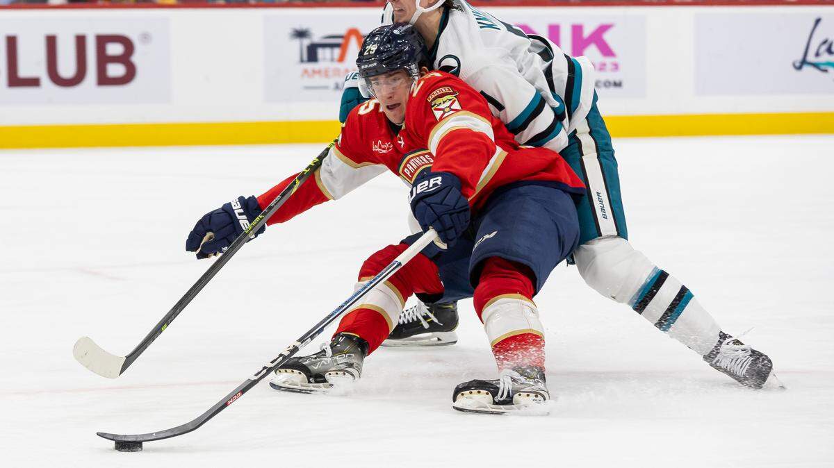 Florida Panthers right wing Mackie Samoskevich (25) and San Jose Sharks defenseman Nikolai Knyzhov (71) compete for the puck in the second period of their NHL game at the Amerant Bank Arena on Tuesday, Oct. 24, 2023, in Sunrise, Fla.