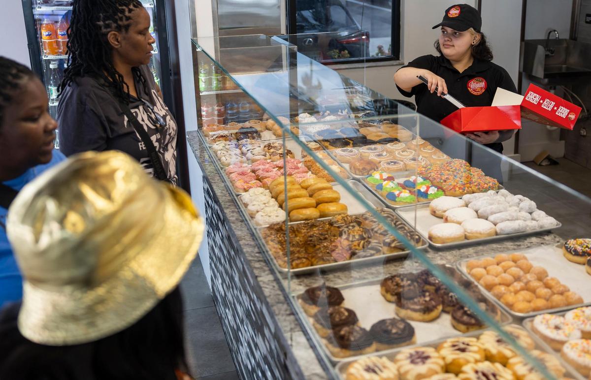Hollywood Donut Factory employee Elizabeth Alvarado, 22, helps customers with an order at the Bird Road store.