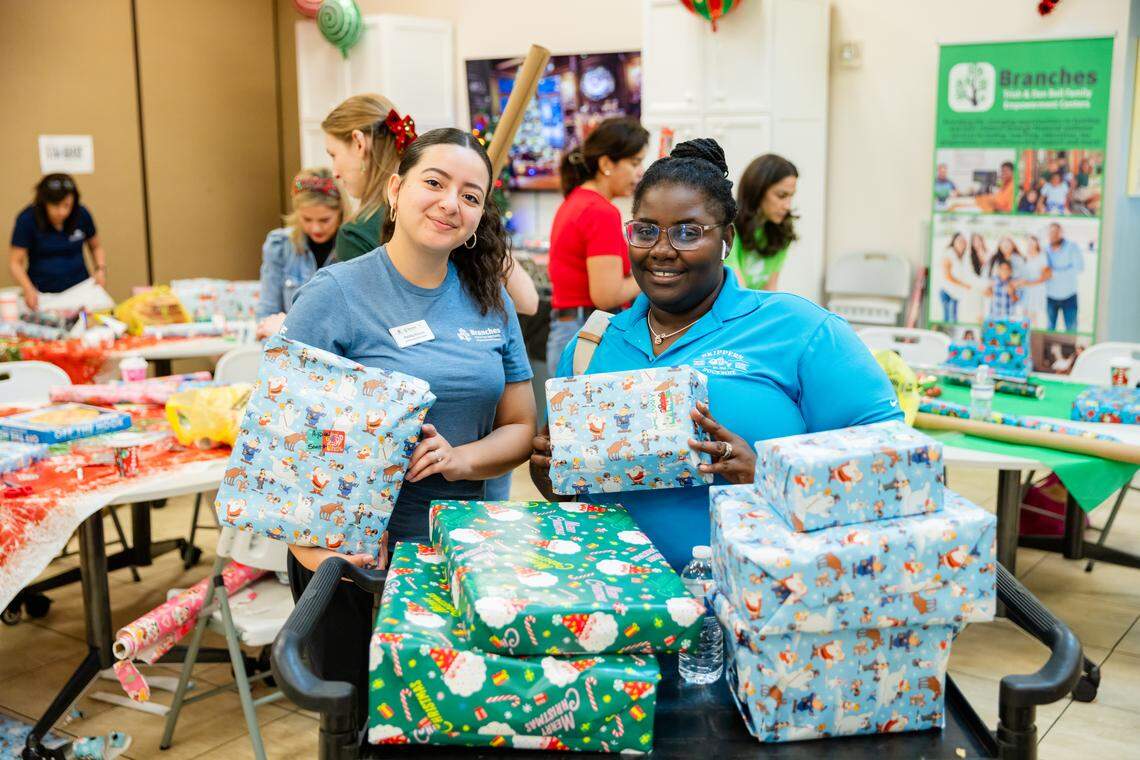 A Branches volunteer helps a family purchase holiday gifts at a 90% discount at the Branches Lakeview “Under The Tree Toy Shops.”&nbsp;