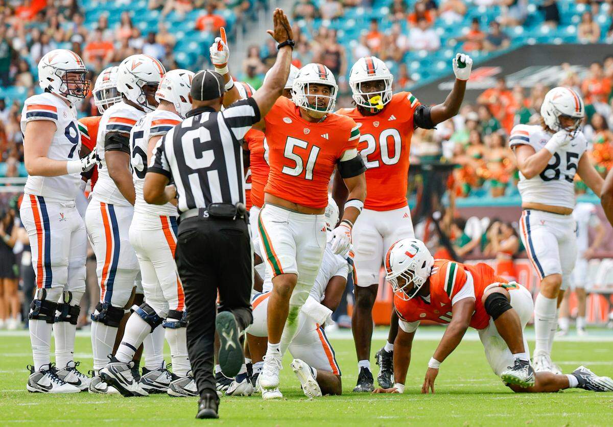 Miami Hurricanes linebacker Francisco Mauigoa (51) reacts after tackling Virginia Cavaliers running back Kobe Pace (5) in the first half at Hard Rock Stadium in Miami Gardens on Saturday, October 28, 2023.