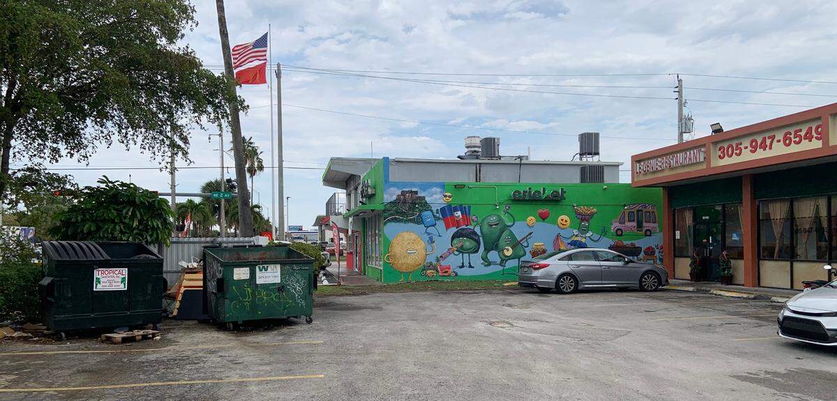 Le Genie Restaurant on the right, dumpsters on the left, open and closer to the front entrance than is healthy.