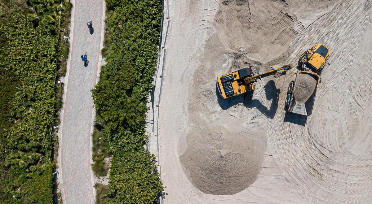 A truck is loaded with sand near Indian Beach Park on Wednesday, Oct. 12, 2022, in Miami Beach, Fla.