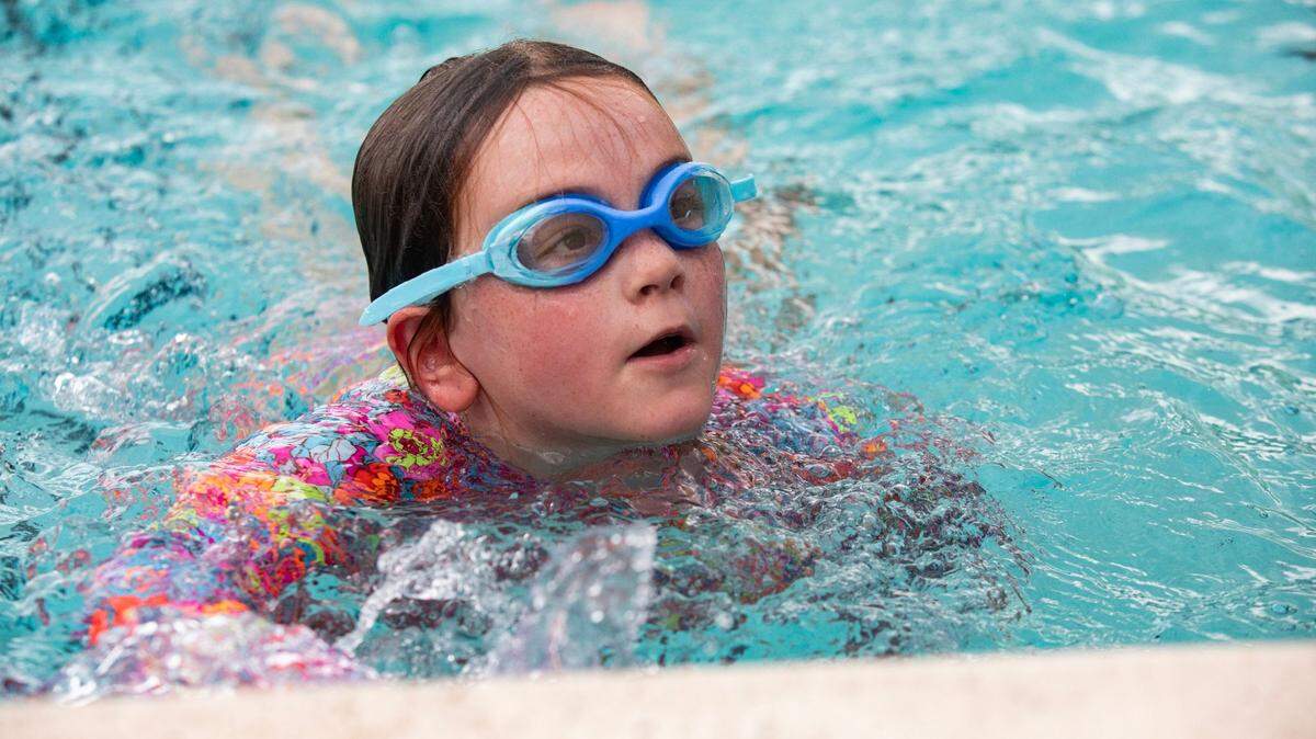 Emmalyn Wadsworth, 8, reaches the end of the pool and finishes her swim test at the reopening of the A.D. Barnes Pool on Thursday, Aug. 10, 2023 in Miami, Fla.