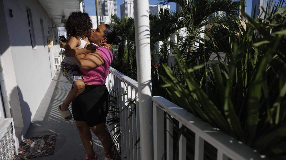 Yudisleine Tejeda Rodriguez, right, picks up her son, Alex Tejada, 4, who is autistic, on the balcony outside their home on Wednesday, Oct. 29, 2025, in Overtown Miami. Rodriguez works 40 hours a week, but caring for him as a low income single mother is tough. They will lose SNAP benefits on November 1 if the federal government shutdown continues. 