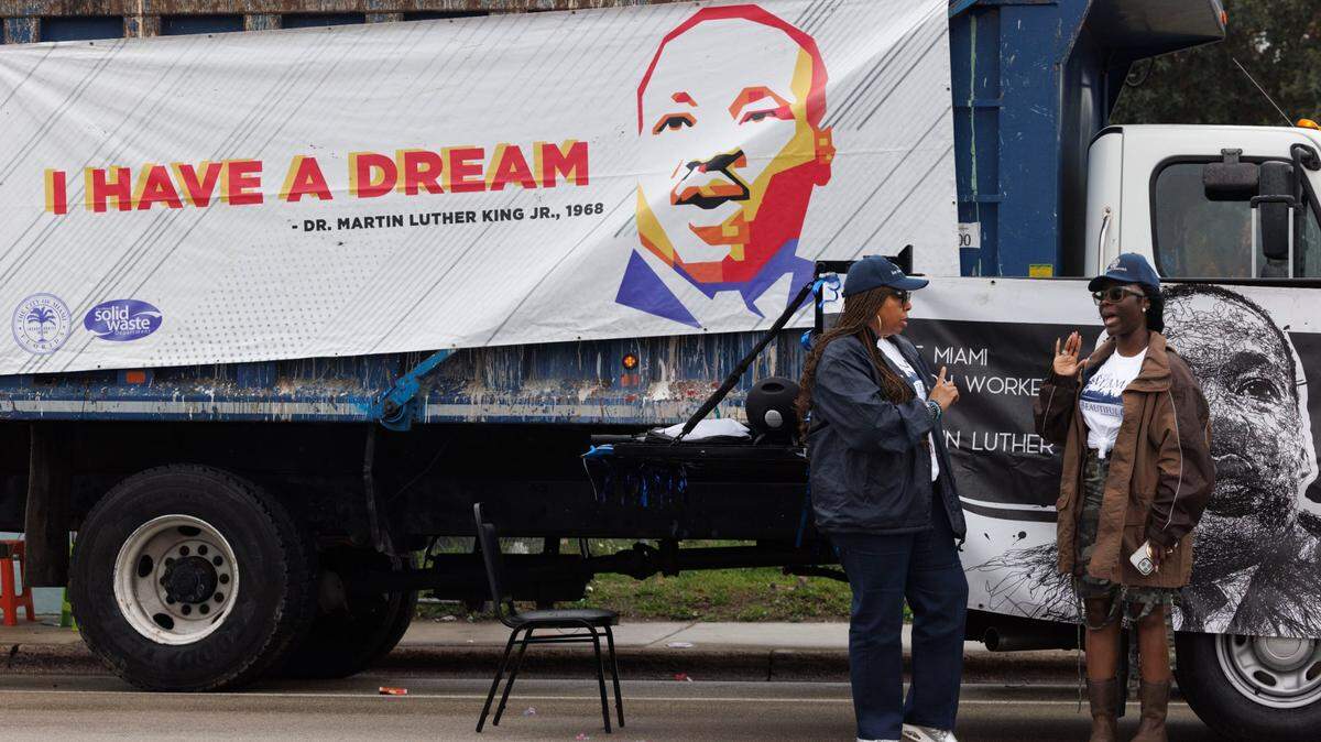 Artier Niettles, left, and Gloria Jenkins, workers for the Miami Solid Waste Department, talk before the Dr. Martin Luther King Jr. Day parade on Jan. 20 in Liberty City.
