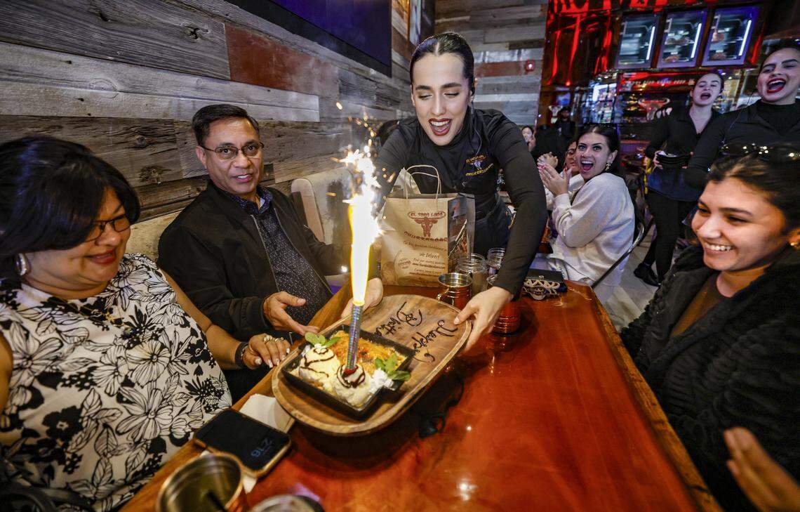 Ymandra Rodriguez serves dessert to diners Martha Duarte, Oliver Duarte and Michelle Duarte, at right, who is celebrating her 31st birthday at El Toro Loco Steakhouse restaurant in Little Havana.