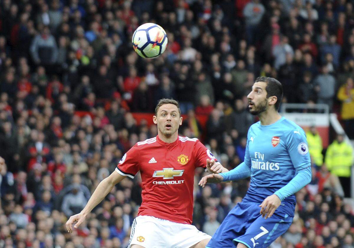 Manchester United's Nemanja Matic, left, duels for the ball with Arsenal's Henrikh Mkhitaryan during the English Premier League soccer match between Manchester United and Arsenal at the Old Trafford stadium in Manchester, England, Sunday, April 29, 2018. (AP Photo/Rui Vieira)