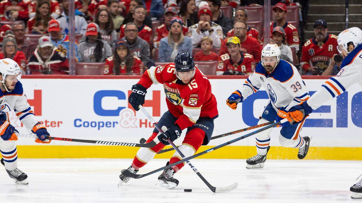 Florida Panthers center Anton Lundell (15) fights for possession of the puck against Edmonton Oilers centers Mattias Janmark (13), Leon Draisaitl (29) and defenseman Vincent Desharnais (73) in the third period of Game 2 of the NHL Stanley Cup Finals at the Amerant Bank Arena on Monday, June 10, 2024, in Sunrise, Fla.