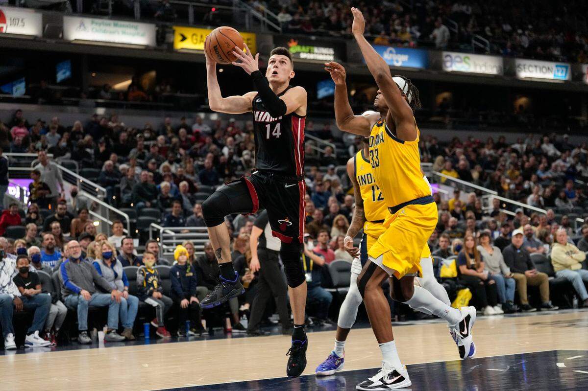 Miami Heat guard Tyler Herro (14) shoots in front of Indiana Pacers center Myles Turner during the first half of an NBA basketball game in Indianapolis, Friday, Dec. 3, 2021. (AP Photo/AJ Mast)