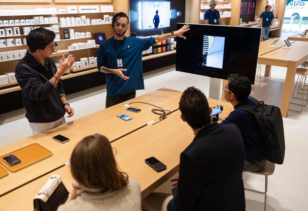 Photographer Erick Quituizaca, left, and Jared Molina, center, an Apple creative pro, give a ‘Today at Apple’ session on improving iPhone photography during a media preview of the new Apple Miami Worldcenter store on Wednesday, Jan. 22, 2025, in downtown Miami, Fla. Apple is set to open its newest store in downtown Miami on Friday, featuring a dedicated pickup area and a biophilic garden.