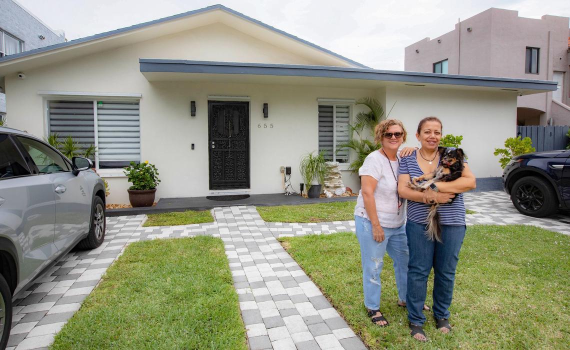 Abbie Cuellar and her partner, Delsa Bernardo, stand in front of their home in Miami with their dog, Lolita, on April 20, 2019.
