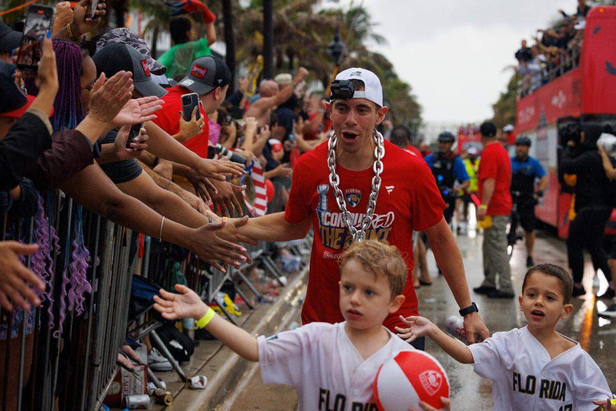 Florida Panthers center Evan Rodrigues (17) high fives fans with his kids during the Florida Panthers Stanley Cup Victory parade on Sunday, June 30, 2024 down Fort Lauderdale Beach. 