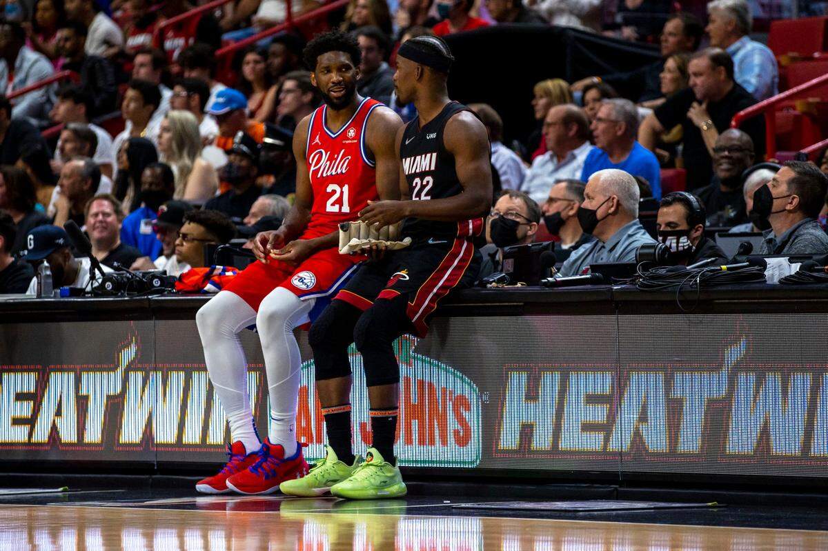 Miami Heat forward Jimmy Butler (22) speaks with Philadelphia 76ers center Joel Embiid (21) as they both wait to sub into the game during the third quarter of an NBA game at FTX Arena in Downtown Miami, Florida, on Saturday, March 5, 2022.