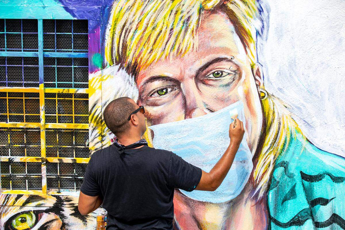 Muralist Kyle Holbrook finishes the additions to his mural of convict Joe Exotic and a tiger, from the now ubiquitous Netflix docu-series called “Tiger King.” Such murals have become the signature of the Wynwood neighborhood.